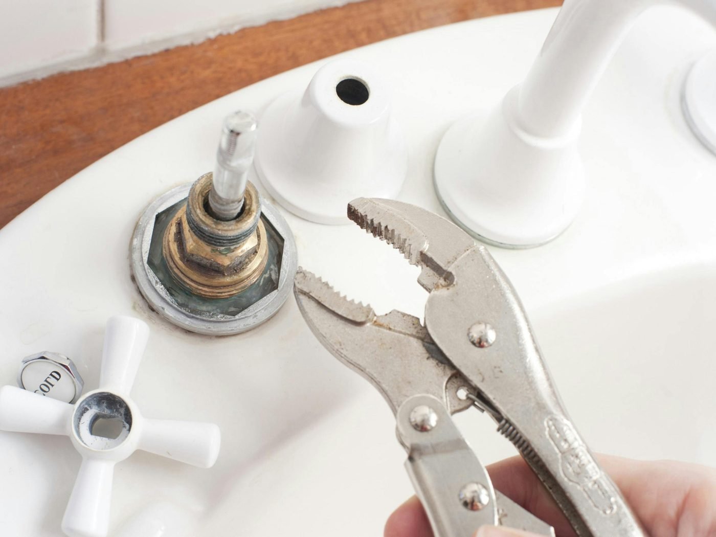 Plumber tightening a basin tap
