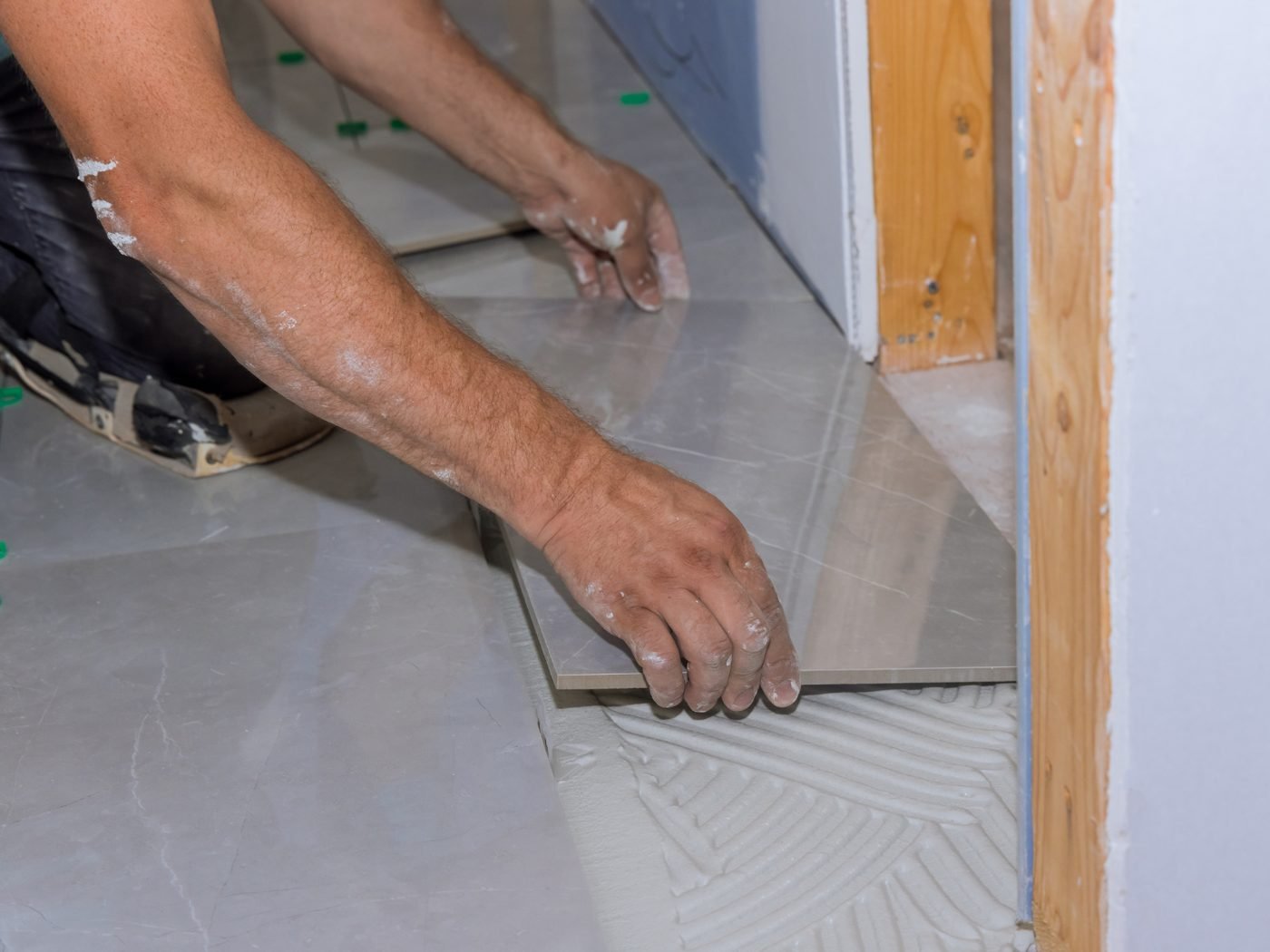 Tiler laying large-format floor tiles